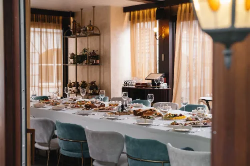 Glasses and plates on long table in restaurant for celebration
